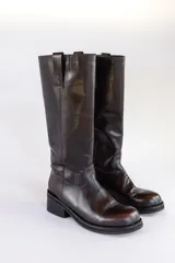 Bota alta de cuero color marrón oscuro, con taco bajo y caña recta.