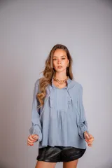 Camisa celeste con volados en cuello y en la parte delantera, con cordones.