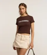 Minifalda color crema de sarga de algodón con bolsillos cargo laterales con hebillas metálicas ajustables.