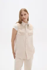 Chaleco color crema con detalles en tejido de espiga en la parte superior y bolsillos.