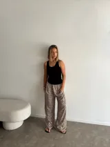 Pantalón ancho de tiro alto con elástico en la cintura y estampado animal print de leopardo en tonos beige y negro.