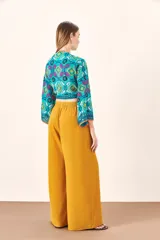 Pantalón palazzo color mostaza, de tiro alto y pierna ancha.