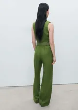 Mono largo color verde oliva, de lino, con cuello camisero, cierre delantero y cinturón trenzado desmontable.
