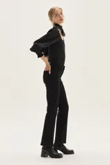 Top negro de calce al cuerpo con escote cuadrado amplio. Mangas largas abullonadas con puños elastizados.
