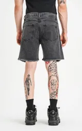 Bermuda de denim rígido, color negro lavado (acid wash), de cinco bolsillos y corte regular, con ruedo desflecado.
