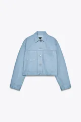 Chaqueta cropped de denim celeste claro, con cuello solapa, manga larga con puños y bolsillos de plastrón en el pecho. Cierre frontal con botones metálicos.