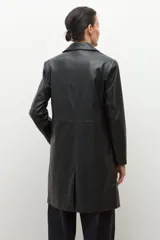 Blazer de mujer color negro, confeccionado en eco cuero, con solapas anchas, cierre frontal de un solo botón y pespuntes visibles.