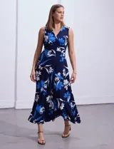 Vestido largo de seda fría con estampado floral en tonos azul y blanco. Tiene escote en V cruzado, cintura con faja plisada y detalles con relieve.