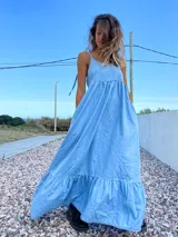 Maxi vestido celeste de jean con breteles regulables y bolsillos laterales.