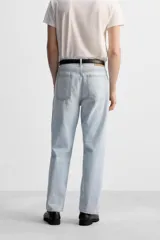 Pantalón de jean gris de corte recto, con cinco bolsillos, efecto lavado y cierre frontal con botones.