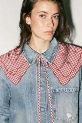 Cuello desmontable con estampado de cuadros vichy rojos y blancos, detalle de flores bordadas y volados en el borde. Se ata al frente con lazos del mismo tejido.