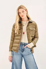 Campera puffer color beige con cuello camisero, cierre con botones a presión, bolsillos con solapa en el pecho y relleno de plumas.