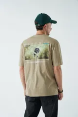 Remera oversize color tostado con arte estampado, diseñada para un look relajado.