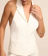 Chaleco blanco de tweed texturizado con espalda abierta, botones delanteros y solapas.