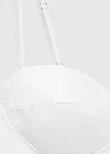 Vestido corto blanco con escote corazón y tirantes finos. Falda con volumen y forro interior.