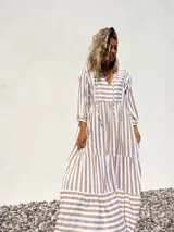 Vestido túnica largo con rayas verticales color beige y blanco, escote en V con lazos y mangas largas.