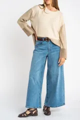 Sweater de punto color beige con mangas largas combinadas en tonos de marrón.