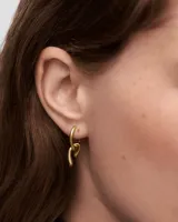 Aros colgantes dorados con forma de eslabón retorcido.