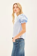 Remera blanca de algodón con mangas balloon de broderie, cuello redondo y tajos laterales.