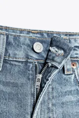 Bermuda de jean celeste, corte mom fit, tiro alto, con cinco bolsillos y ruedo doblado.