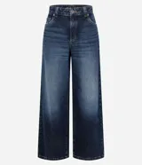 Pantalón de jean de mujer, modelo wide leg, con cintura baja tradicional, cierre por botón metálico y cremallera, y bolsillos curvos delanteros y traseros.