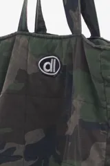 Bolso tipo tote bag con estampado de camuflaje y logo bordado.
