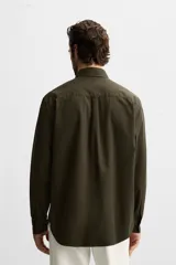 Camisa verde oscuro de corte regular, confeccionada en tejido de mezcla de algodón y lyocell. Tiene cuello italiano, manga larga con puños abotonados y cierre frontal con botones.