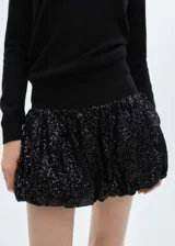 Minifalda negra con lentejuelas, cintura elástica y corte evasé.