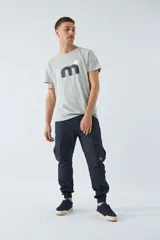 Pantalón cargo gris oscuro, corte slim, con cierre de botón y cremallera, trabillas para cinturón, bolsillos cargo con botón y puños ajustados.