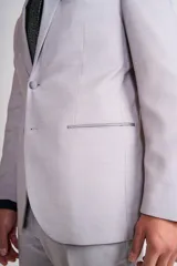 Traje de vestir gris claro, compuesto por saco de dos botones con solapa de muesca, bolsillo de ojal y dos bolsillos de parche. Incluye pantalón de vestir a juego.