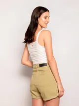 Short color verde militar, tiro alto, corte amplio, con pinzas en el frente, bolsillos laterales y traseros, y dobladillo arremangado.