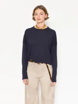 Sweater tejido suave y flojo, color crudo, con cuello redondo y mangas largas.