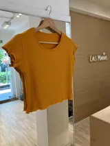 Remera de morley color mostaza, de manga corta con terminación fruncida.