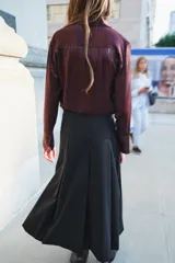 Falda midi negra de tiro medio confeccionada en hilatura con lana. Diseño con tablas y cierre con cremallera oculta en costura.