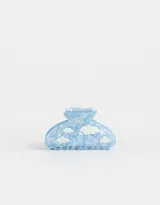 Broche para el pelo de plástico celeste con estampado de nubes blancas.