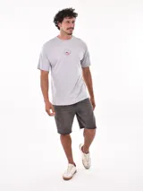 Remera negra de corte oversized con estampado circular en el pecho que incluye una palmera, una ola y la palabra 'Paradise'.
