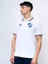 Remera polo azul con cierre, puños y cuello con detalle tricolor. Incluye logo de Umbro y escudo del Club Nacional de Football.