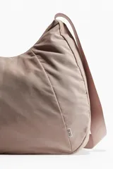 Bolso de deporte color rosa con correa ancha ajustable y cierre.