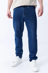 Pantalón de jean azul oscuro, corte slim fit, tiro medio y bolsillos delanteros y traseros.