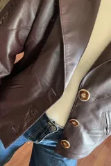 Campera bomber de cuero color vino con cuello de piel sintética desmontable y botones grandes color carey.