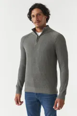Sweater gris de punto con cuello alto y medio cierre con cremallera.