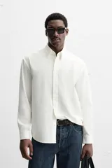 Camisa azul marino de algodón con textura jacquard, corte relaxed fit, cuello solapa, manga larga con puños abotonados y cierre frontal con botones.