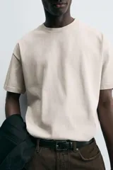 Camiseta blanca de algodón compacto, corte relaxed fit, cuello redondo y mangas cortas.