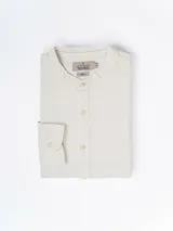 Camisa de manga larga color crudo, confeccionada en lino. Presenta cuello mao y cierre frontal con botones. Marca La Dolphina.