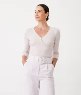 Blusa de punto color lila claro, ajustada al cuerpo, con escote cruzado en V y mangas tres cuartos.