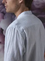 Camisa blanca de lino y algodón con cuello mao y manga larga.