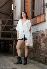 Blusa blanca de mangas cortas con volados, escote en V y lazo de ajuste.