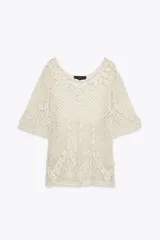 Top de crochet color crema, con cuello redondo y mangas cortas.