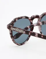 Gafas de sol Hawkers unisex, modelo Warwick, con montura redonda Carey Grey y lentes Rose Gold.
