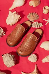 Mocasín mule de cuero negro con capellada tejida.